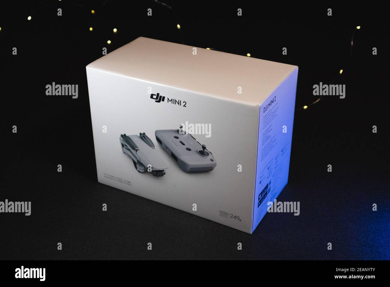 Kiev, Ucraina - 02 febbraio 2021: DJI Mavic Mini 2 drone Bundle Fly More Combo bianco confezione su sfondo nero in effetto luce blu Foto Stock