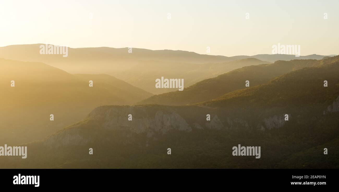 Tramonto in montagna di Crimea, paesaggio tramonto con raggi di sole e montagne. Foto Stock