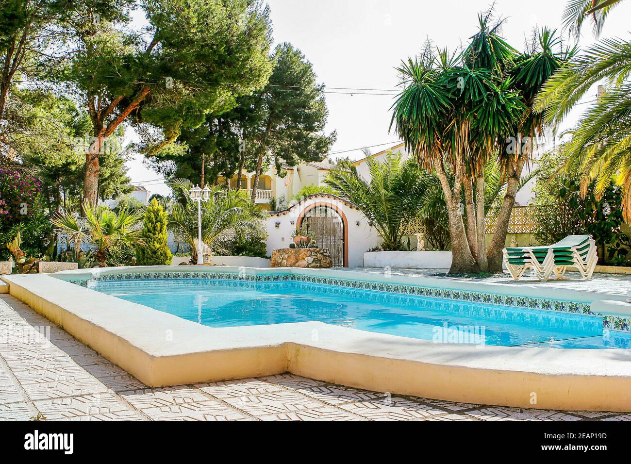 Villa classica spagnola a Moraira con piscina immersa in un giardino mediterraneo maturo, in Spagna Foto Stock