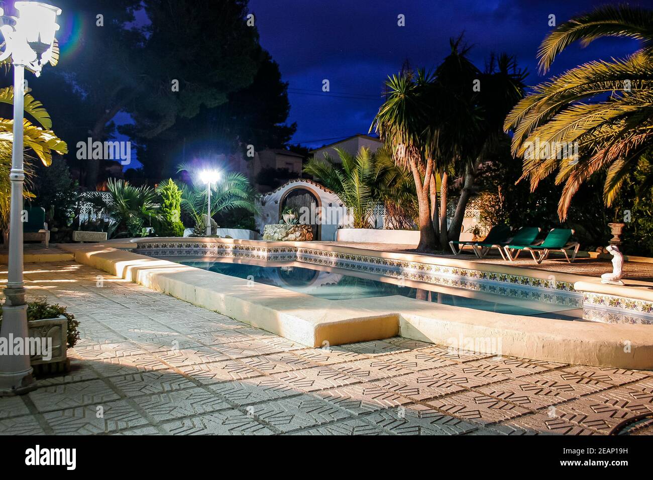Piscina di notte in un giardino maturo in una classica villa spagnola a Moraira, Spagna Foto Stock