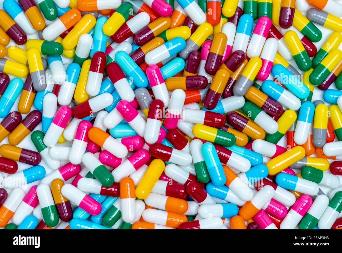 Molte pillole di capsula. Pillole della capsula vista dall'alto. Pillole in capsula blu, gialla, verde, rosa, rossa, arancione, bianca e grigia. Concetto di sanità e medicina. Industria farmaceutica. Bilancio sanitario. Foto Stock