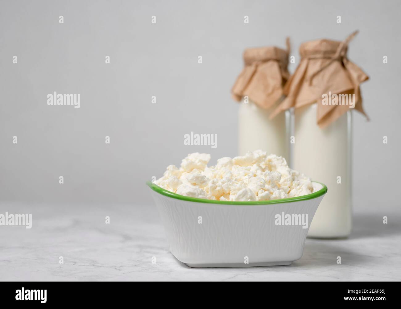 Bottiglie con latte fresco e formaggio di cottage. I latticini grezzi sono una fonte di calcio e proteine Foto Stock