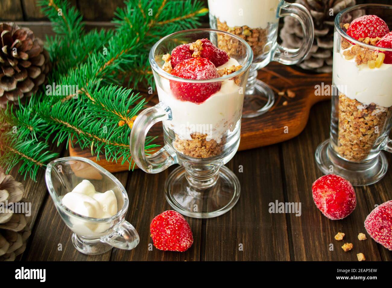 yogurt sano con fragole e muesli in vetro su un ambiente rustico tavolo. Foto Stock