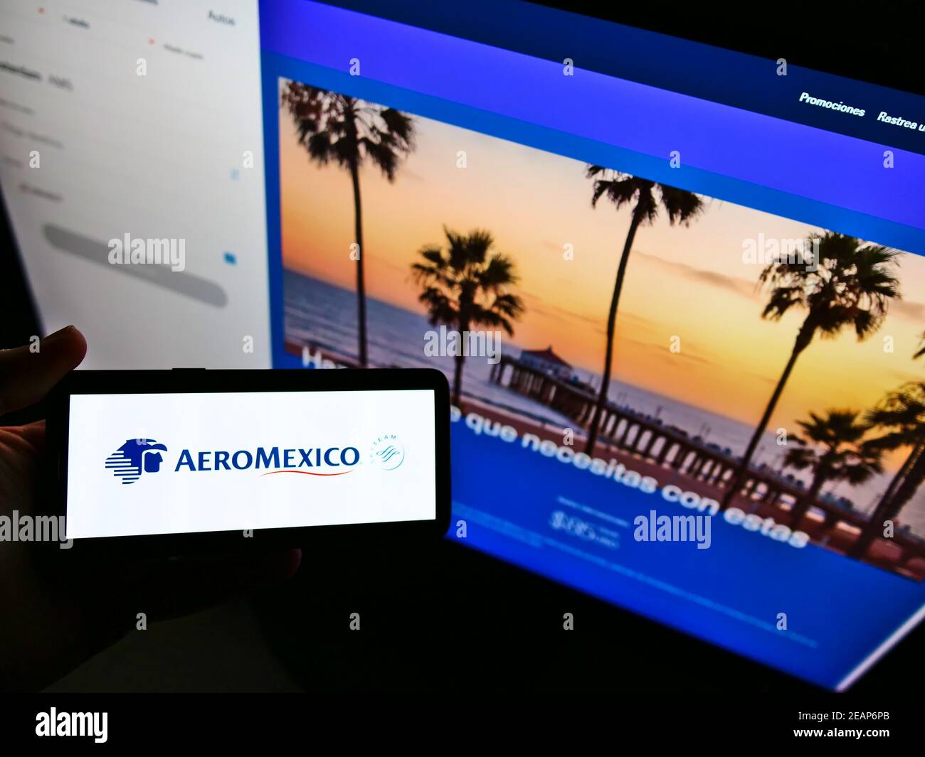 Persona che detiene smartphone con il logo della compagnia aerea messicana Aerovías de México (Aeroméxico) sullo schermo davanti al sito web. Mettere a fuoco il display del telefono. Foto Stock