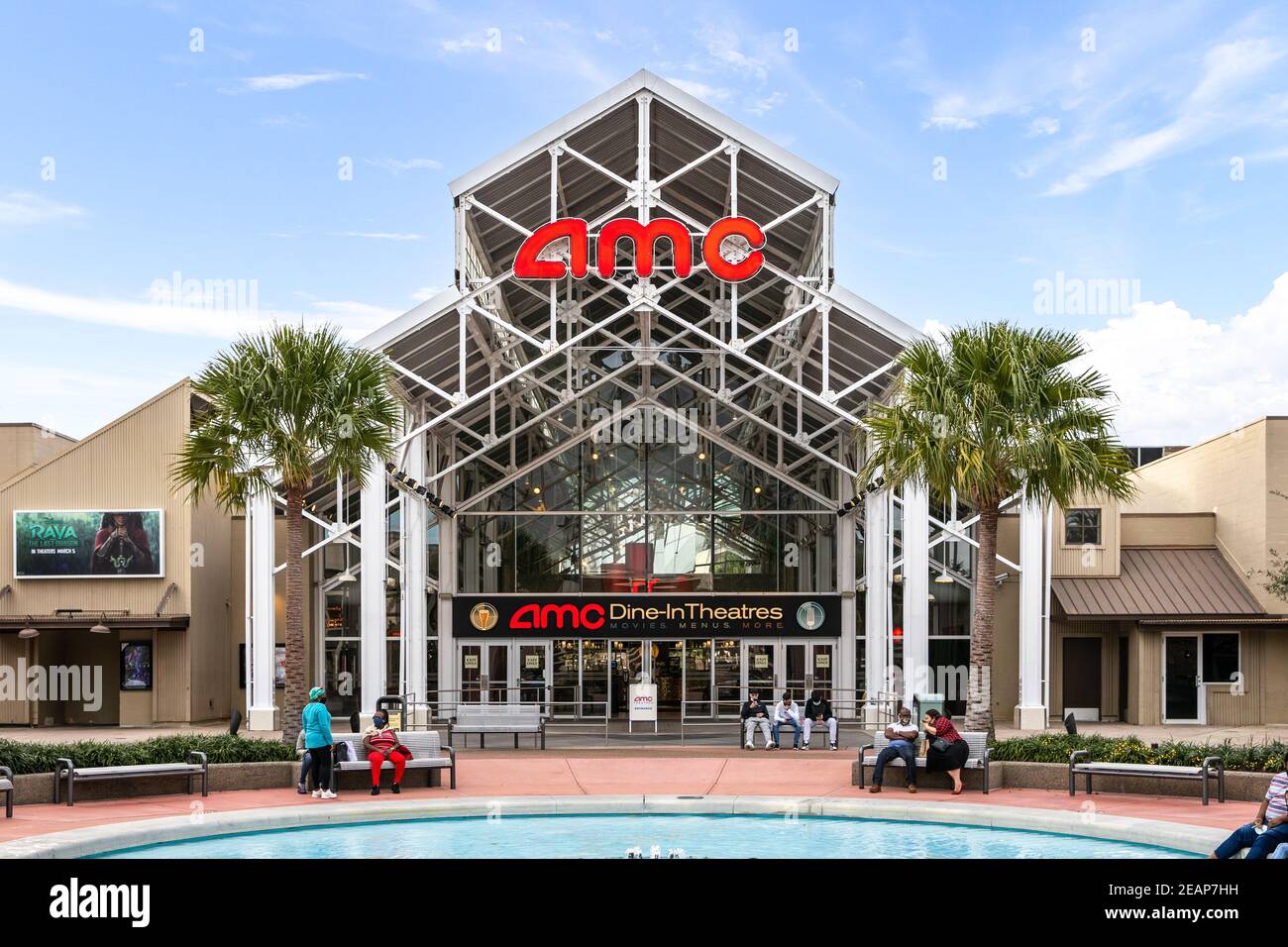 L'esterno di un cinema AMC Dine-in con palme, persone e una fontana di fronte. Foto Stock