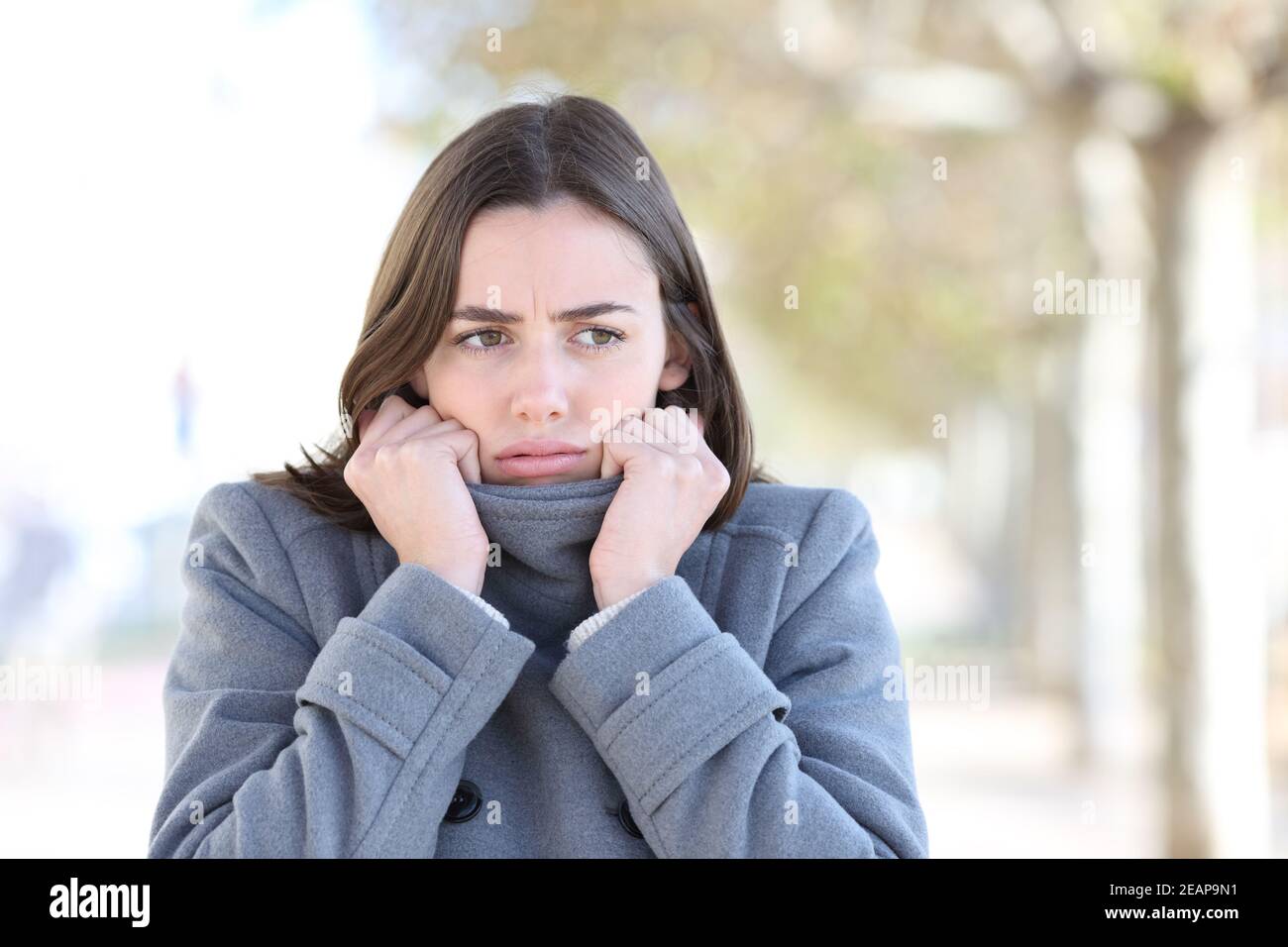 Donna arrabbiata che fa freddo in inverno per strada Foto Stock