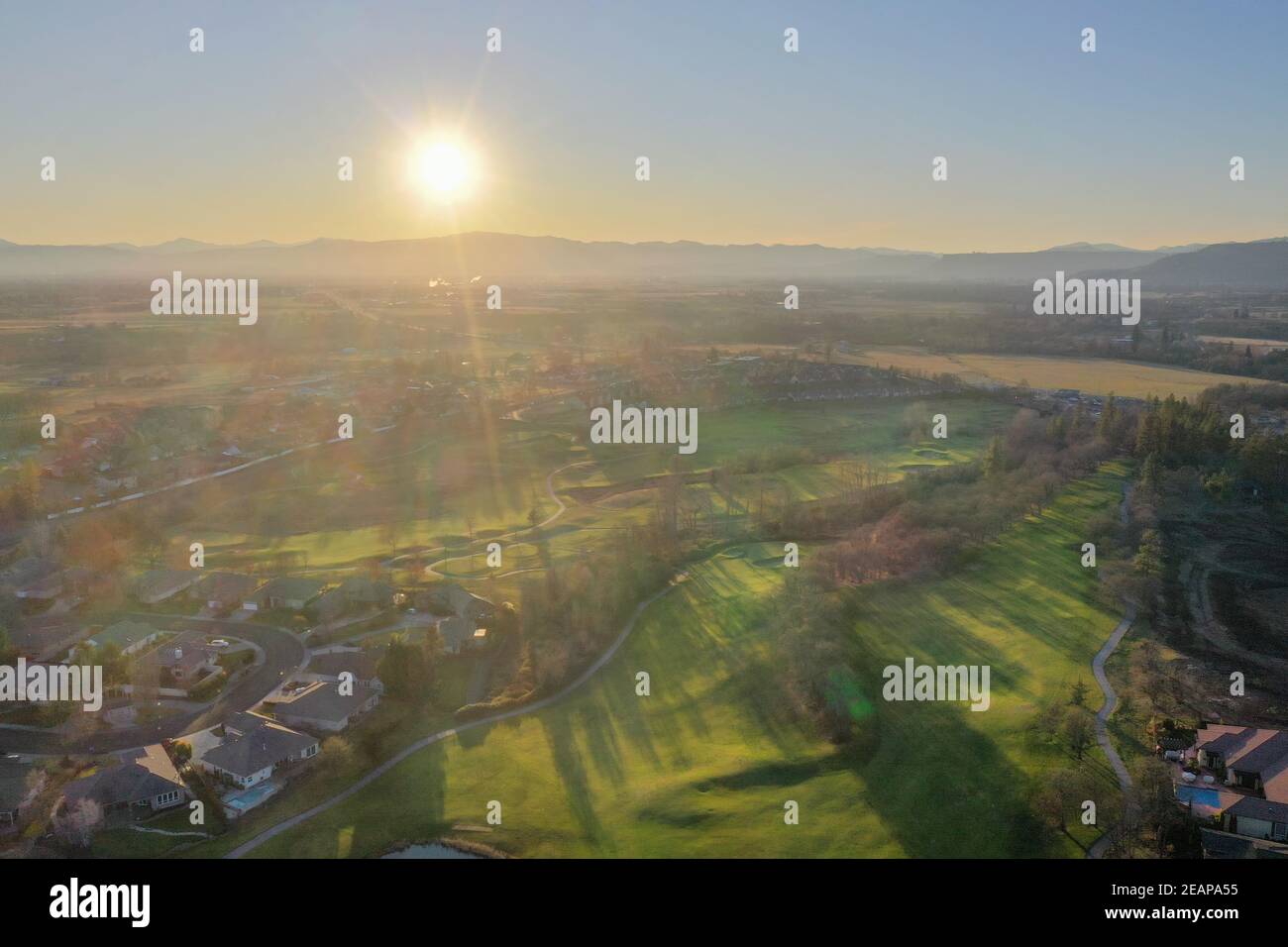 Piccola città e campi verdi durante il bellissimo tramonto Foto Stock