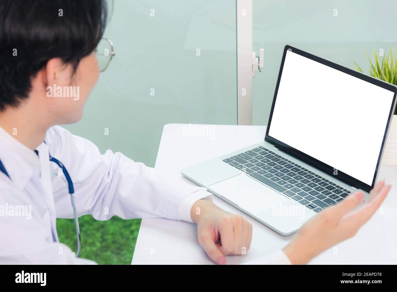 Medico uomo che indossa un vestito medico video conferenza al paziente in ospedale Foto Stock