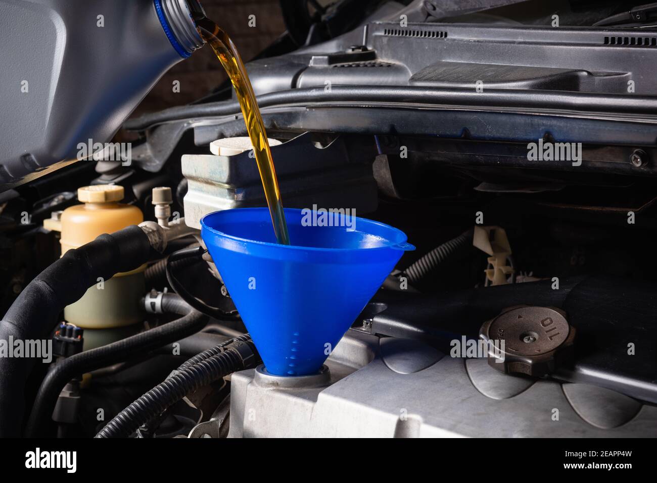 Meccanico in servizio per riparare la vettura, sostituire l'olio lubrificante Foto Stock