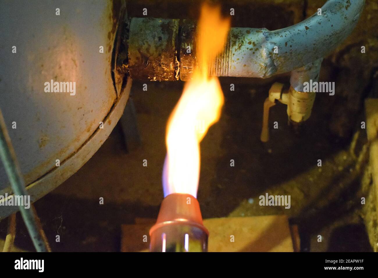 Il riscaldamento di una tubazione in acciaio con un cannello. La fiamma di un cannello Foto Stock