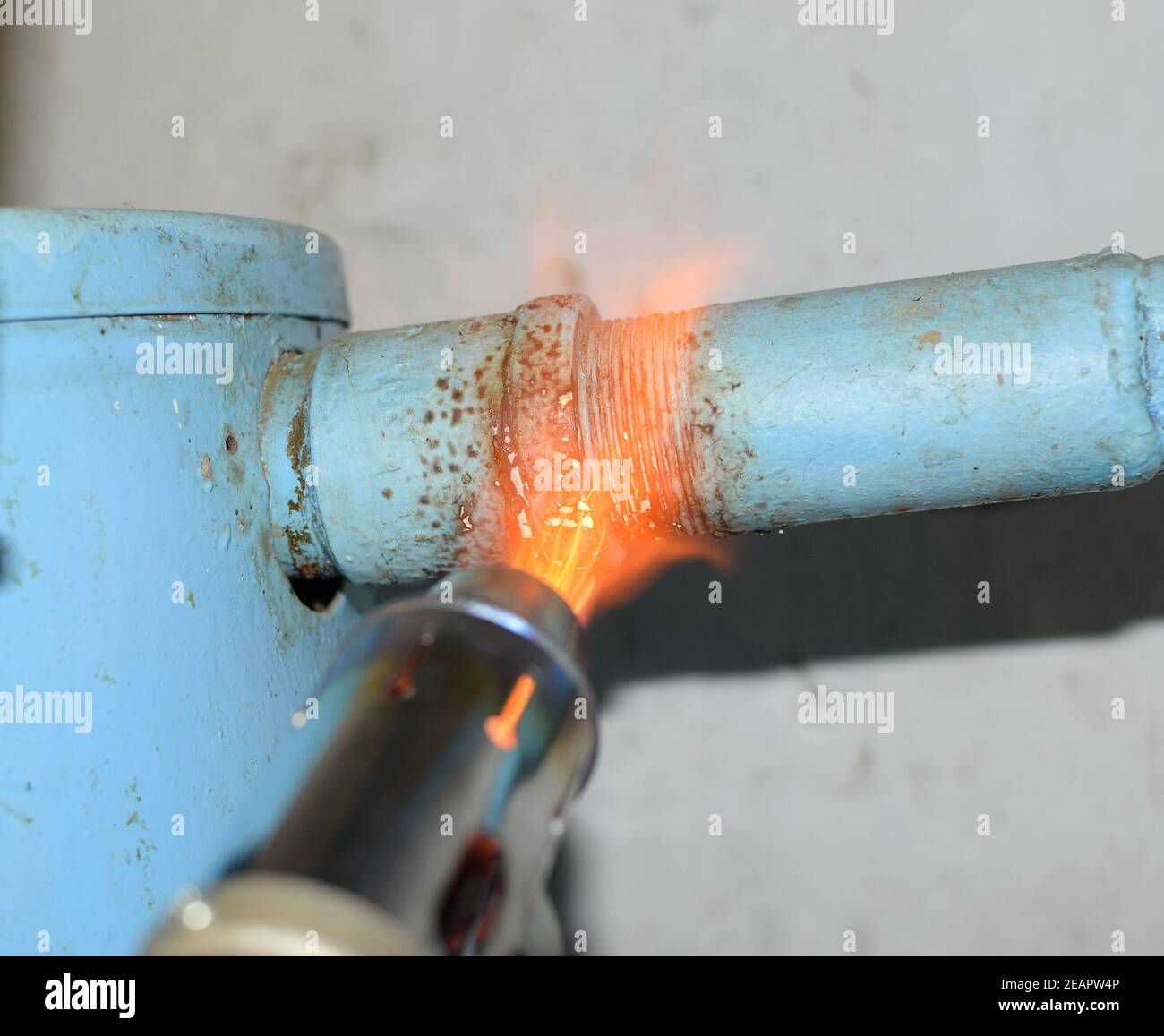 Il riscaldamento di una tubazione in acciaio con un cannello. La fiamma di un cannello Foto Stock
