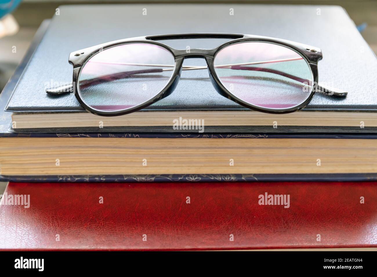 Occhiali da lettura messi su libri di copertina rigida Foto Stock