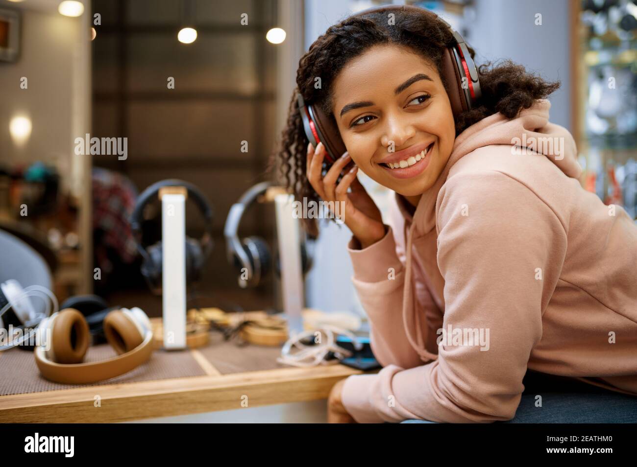 Acquirente che sceglie le cuffie nel negozio audio Foto Stock