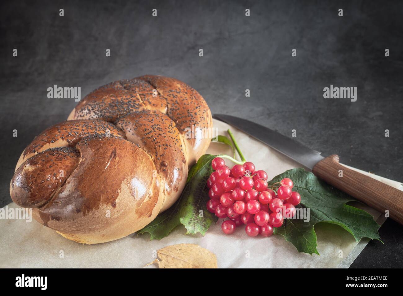 Una pagnotta di pane bianco e bacche di viburnum Foto Stock