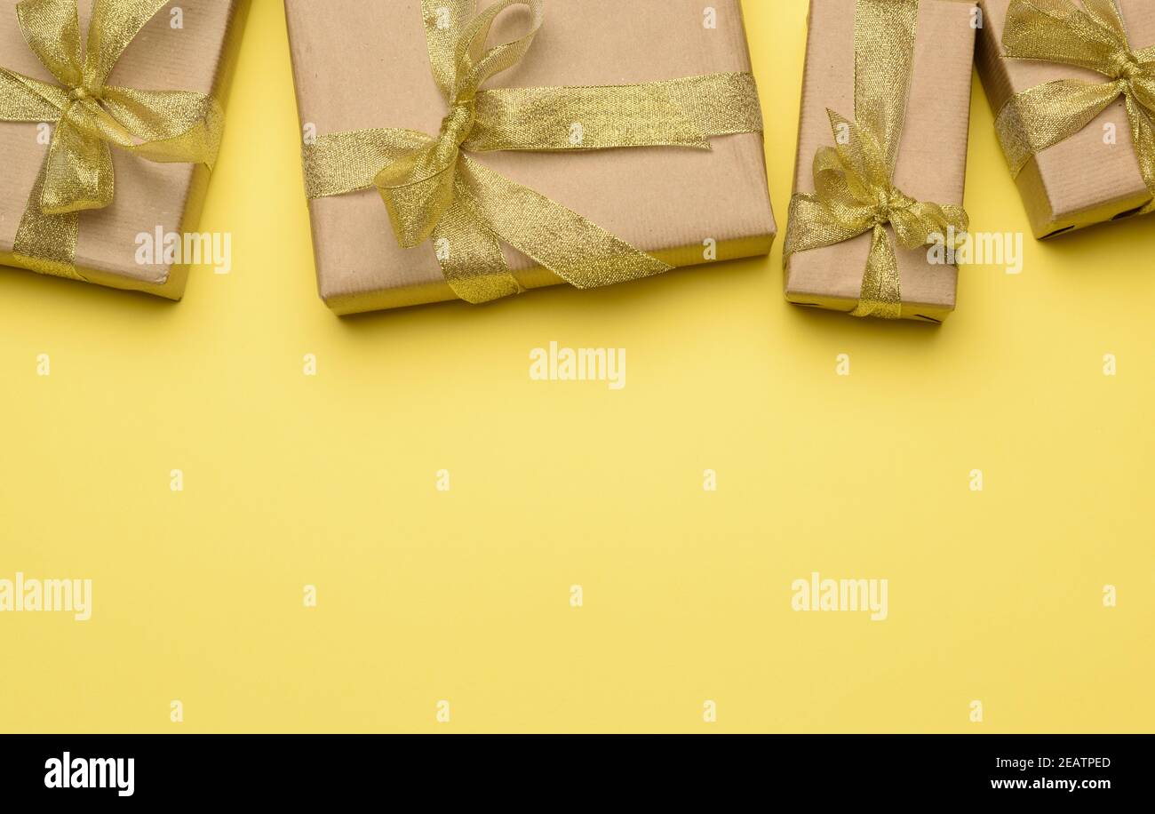 scatola avvolta in carta marrone e legata con un dorato nastro con un arco Foto Stock