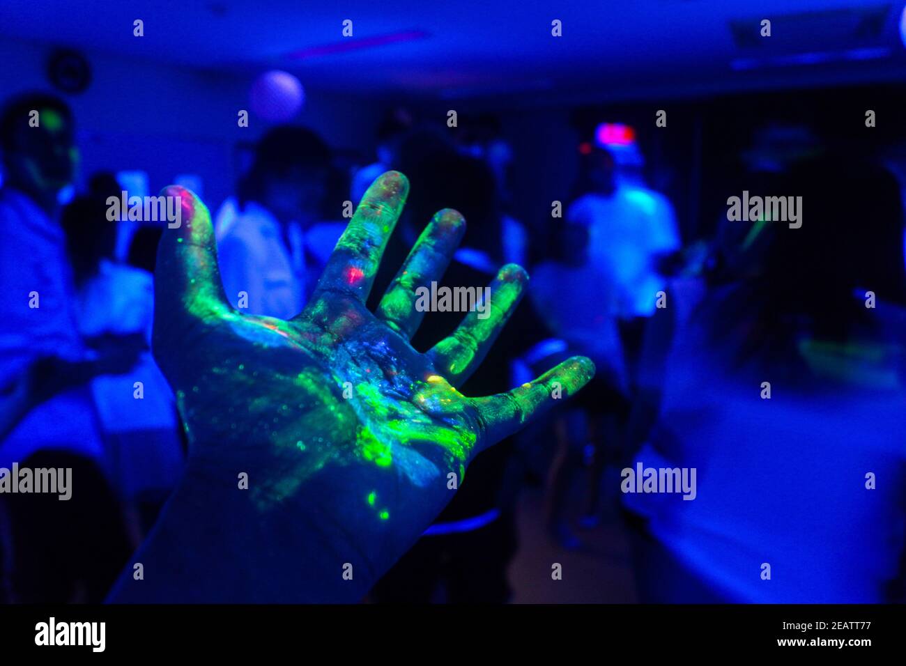 Mano con una vernice fluorescente Foto Stock