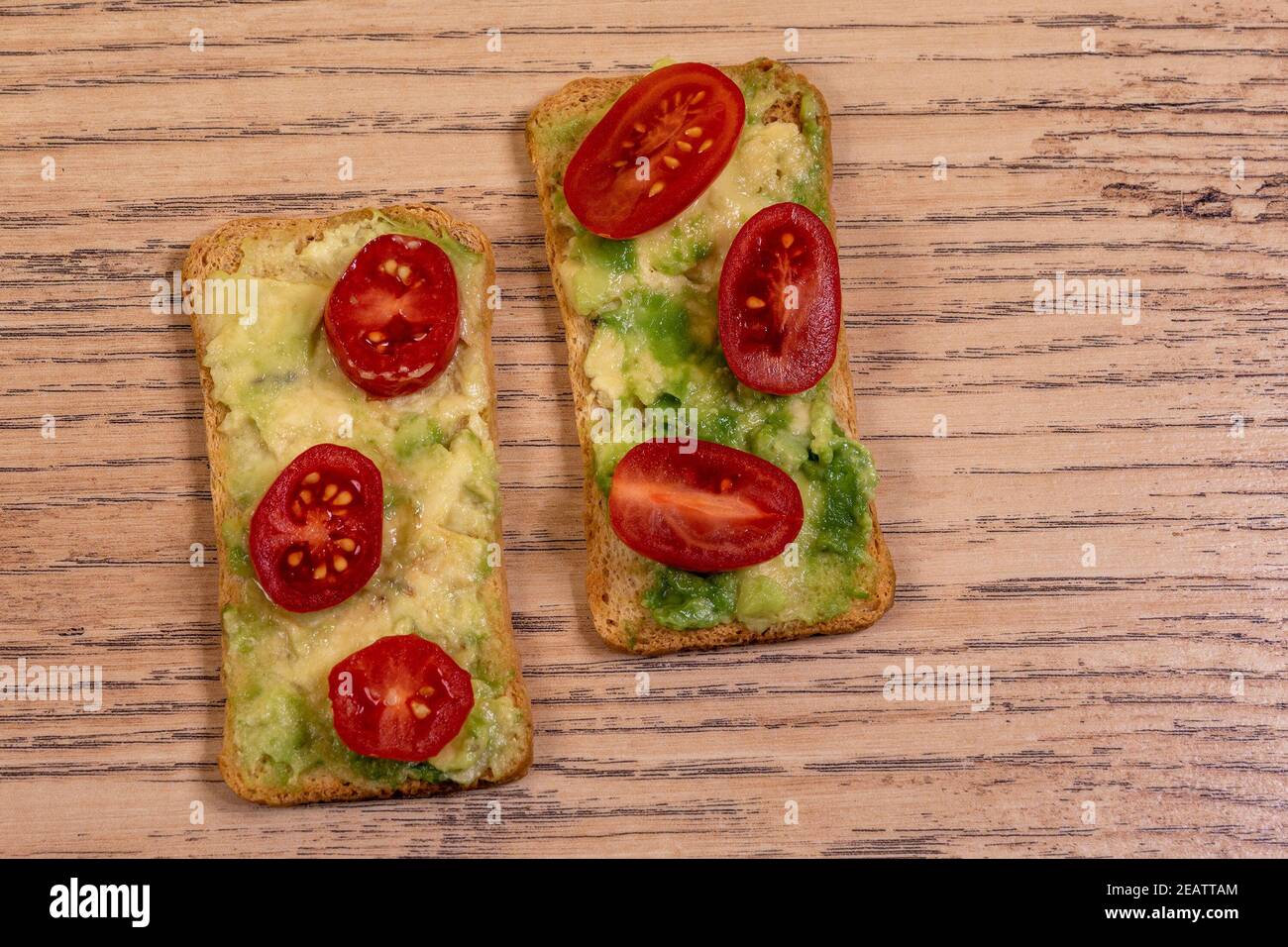Due crostini con avocado e pomodori sherry Foto Stock