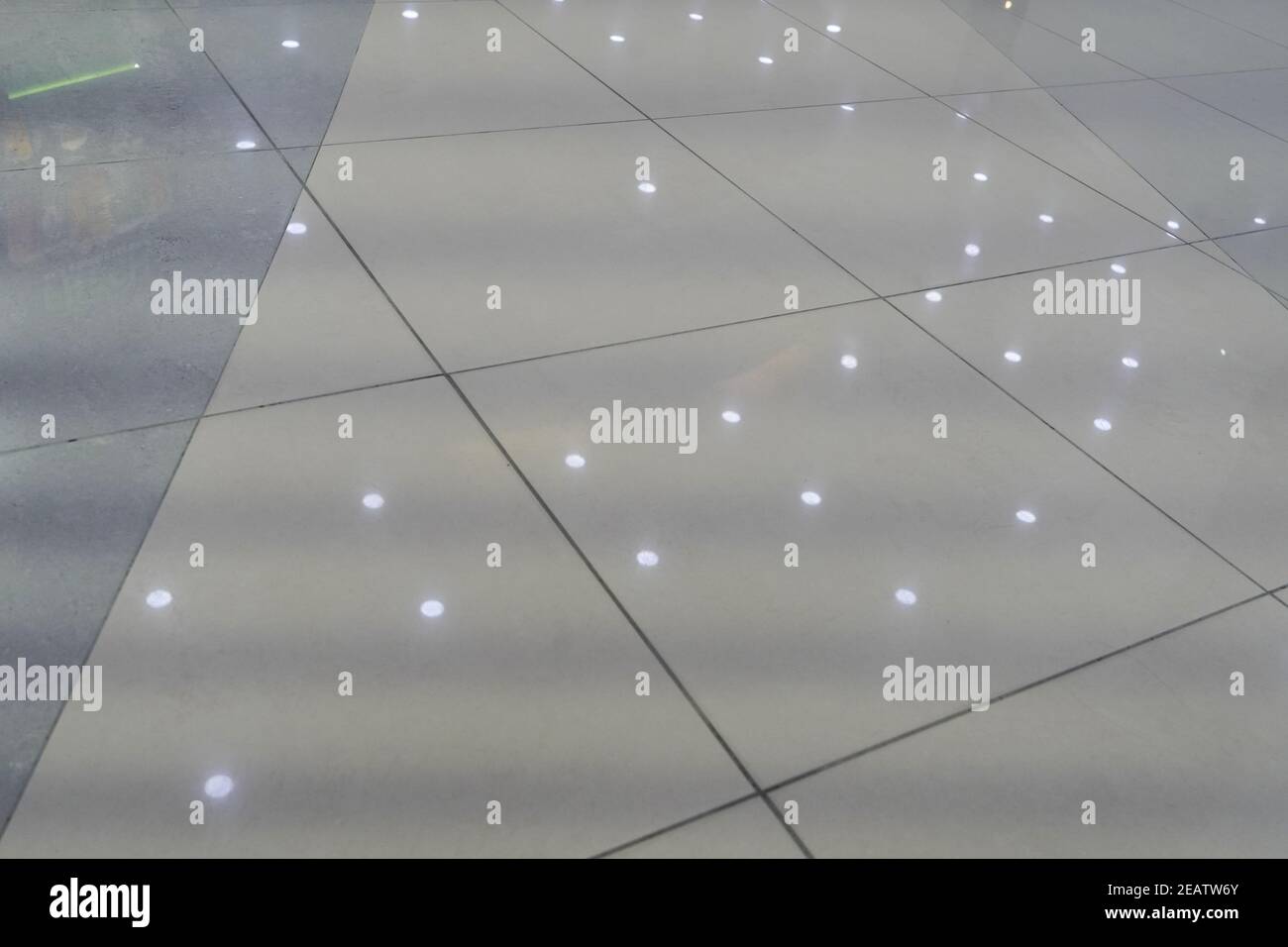 Pavimento in marmo in un edificio pubblico con luci a soffitto che riflettono Foto Stock