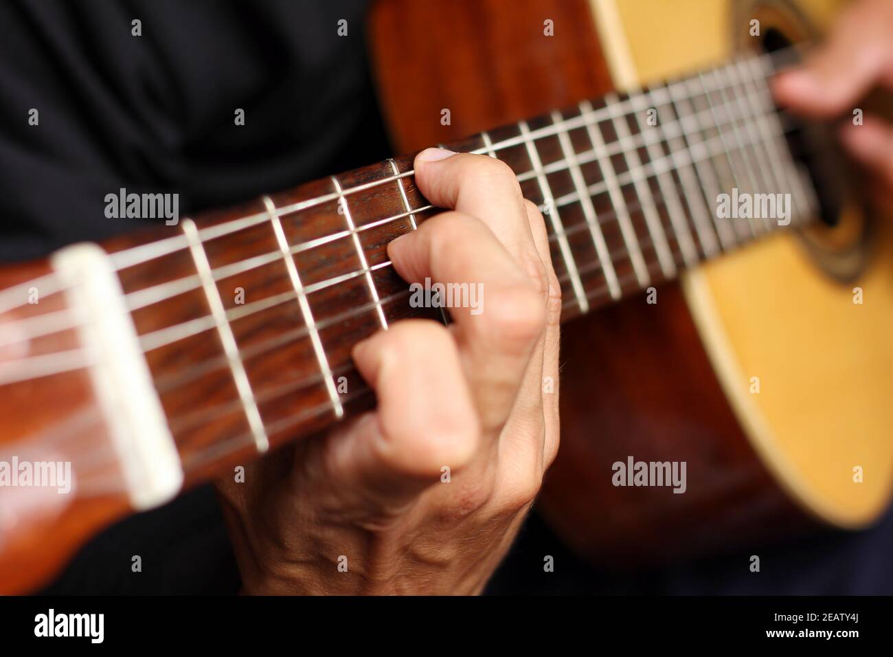 primo piano chitarra acustica in mani di musicista Foto Stock