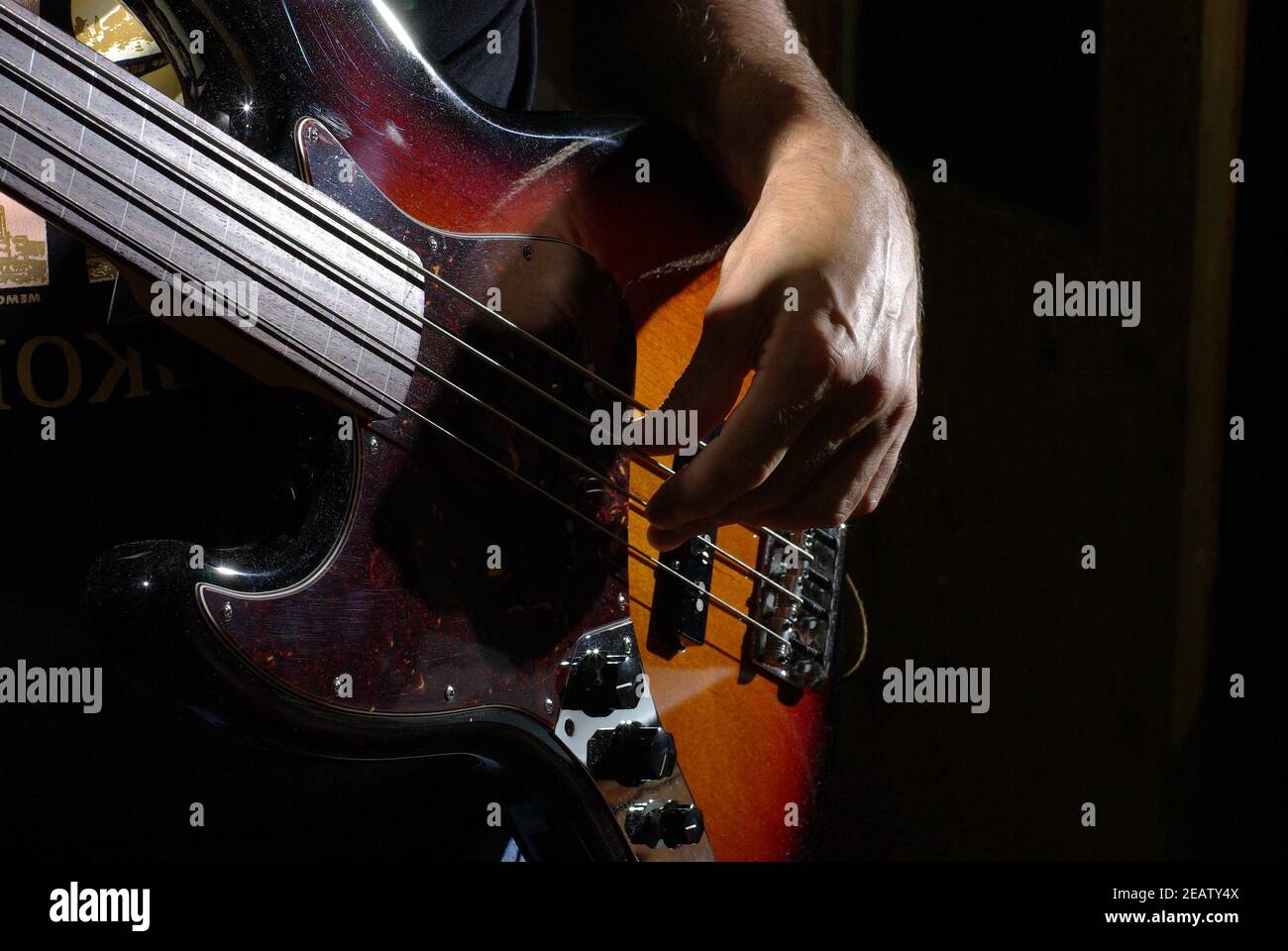 Uomo che suona una chitarra basso con corpo marrone Foto Stock