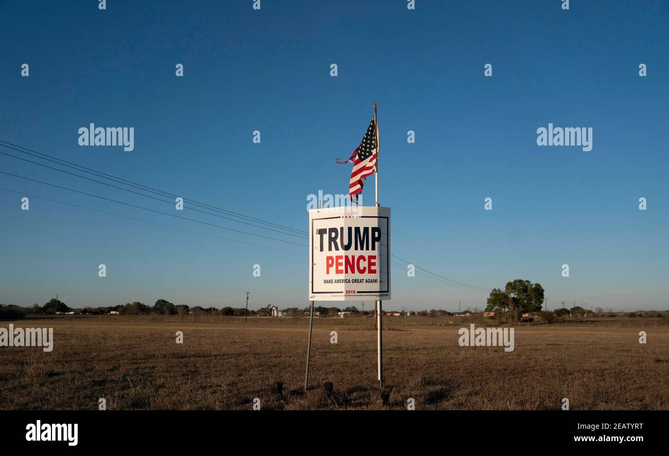 Smithville, Texas, Stati Uniti. 2 Feb 2021. Un agricoltore al di fuori di Smithville nella contea di Bastrop, Texas, vola una bandiera americana leggermente distrutta su una campagna Trump-Pence firma tre mesi dopo le elezioni di novembre dove il biglietto repubblicano perso. Molti texani rurali si rifiutano ancora di accettare una vittoria democratica. Credit: Bob Daemmrich/ZUMA Wire/Alamy Live News Foto Stock