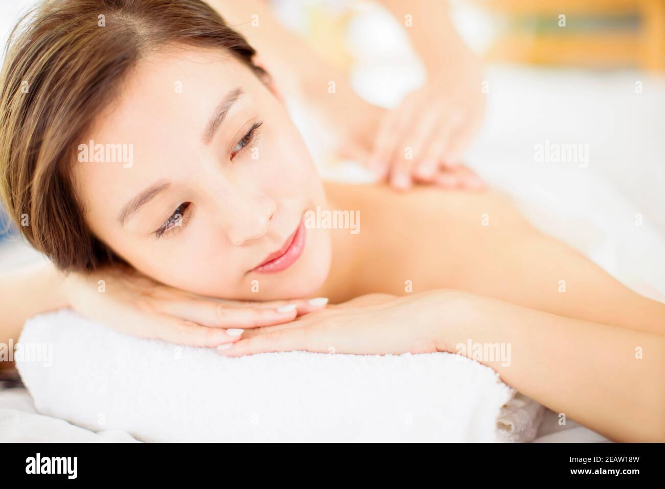 Rilassante giovane donna godere di massaggio nel salone spa Foto Stock