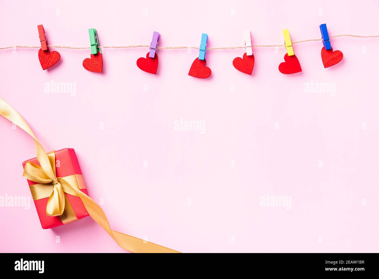 valentine rosse a forma di cuore appese con clip in legno per l'amore e. confezione regalo rossa Foto Stock