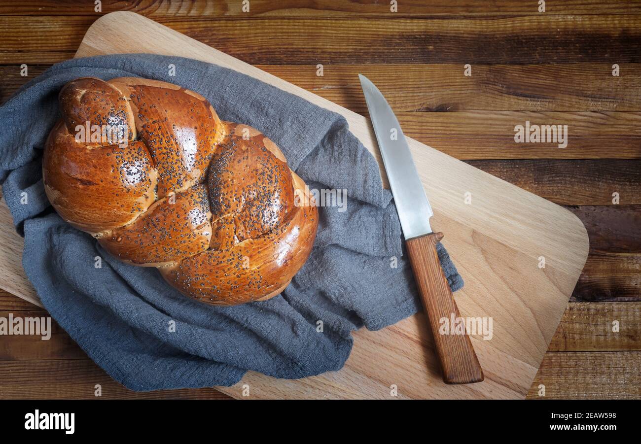 Una pagnotta di pane bianco e un coltello sul Tavola da cucina Foto Stock
