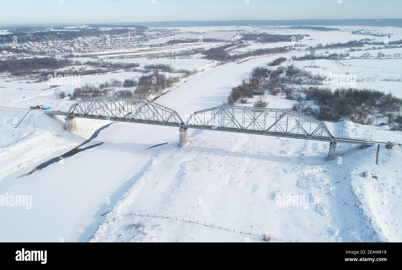 Ponte ferroviario in inverno neve tempo aereo sopra drone vista Foto Stock