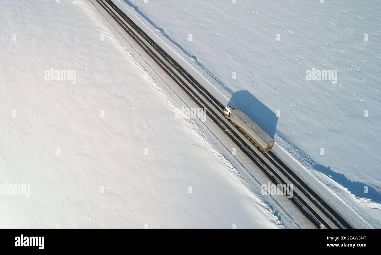 Un autocarro consegna il carico sopra il drone vista dall'alto. Tema del trasporto invernale Foto Stock