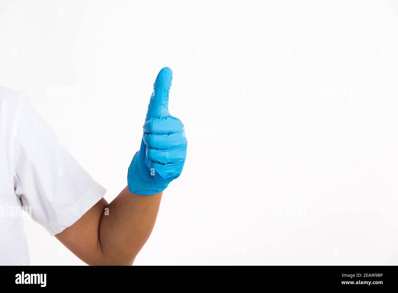 Donna che indossa un guanto di gomma blu con il pollice in alto segno Foto Stock