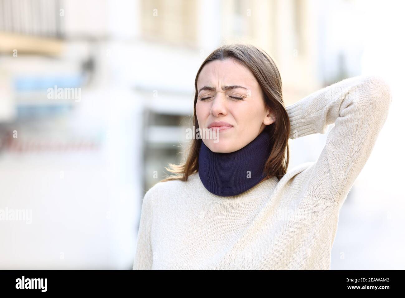 Donna che indossa una tuta da collo che soffre di dolore cervicale Foto Stock