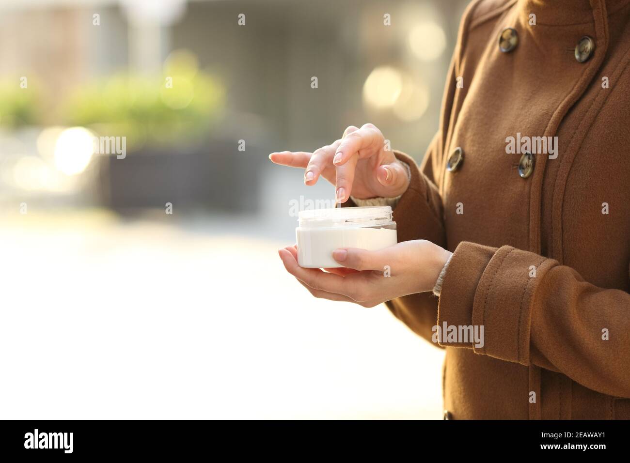Mani donna che tengono crema idratante pronta per l'applicazione Foto Stock