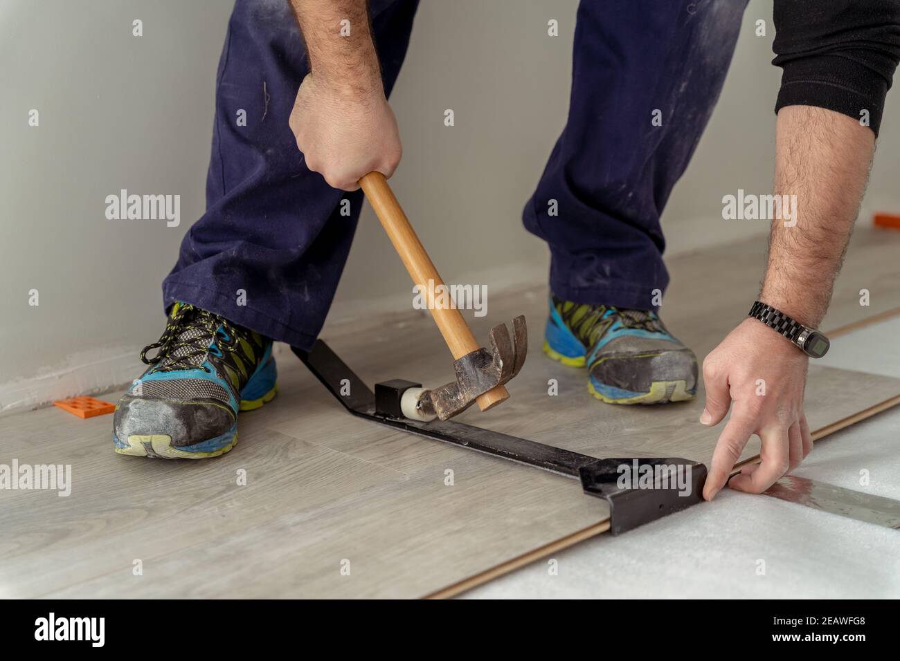 primo piano di un uomo lavoratore che si adatta pavimento in laminato Foto Stock