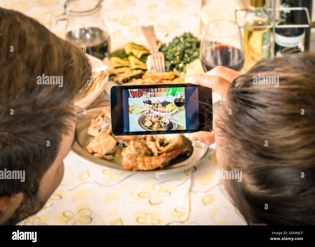 Coppia di fidanzati e fidanzati che prendono un selfie del cibo dentro Ristorante cena - Moda di catturare l'istante con moderno smartphone a pranzo Foto Stock