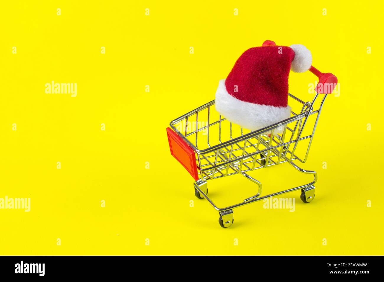 Cappello di Natale rosso Babbo Natale su sfondo giallo nel carrello su  sfondo giallo Foto stock - Alamy