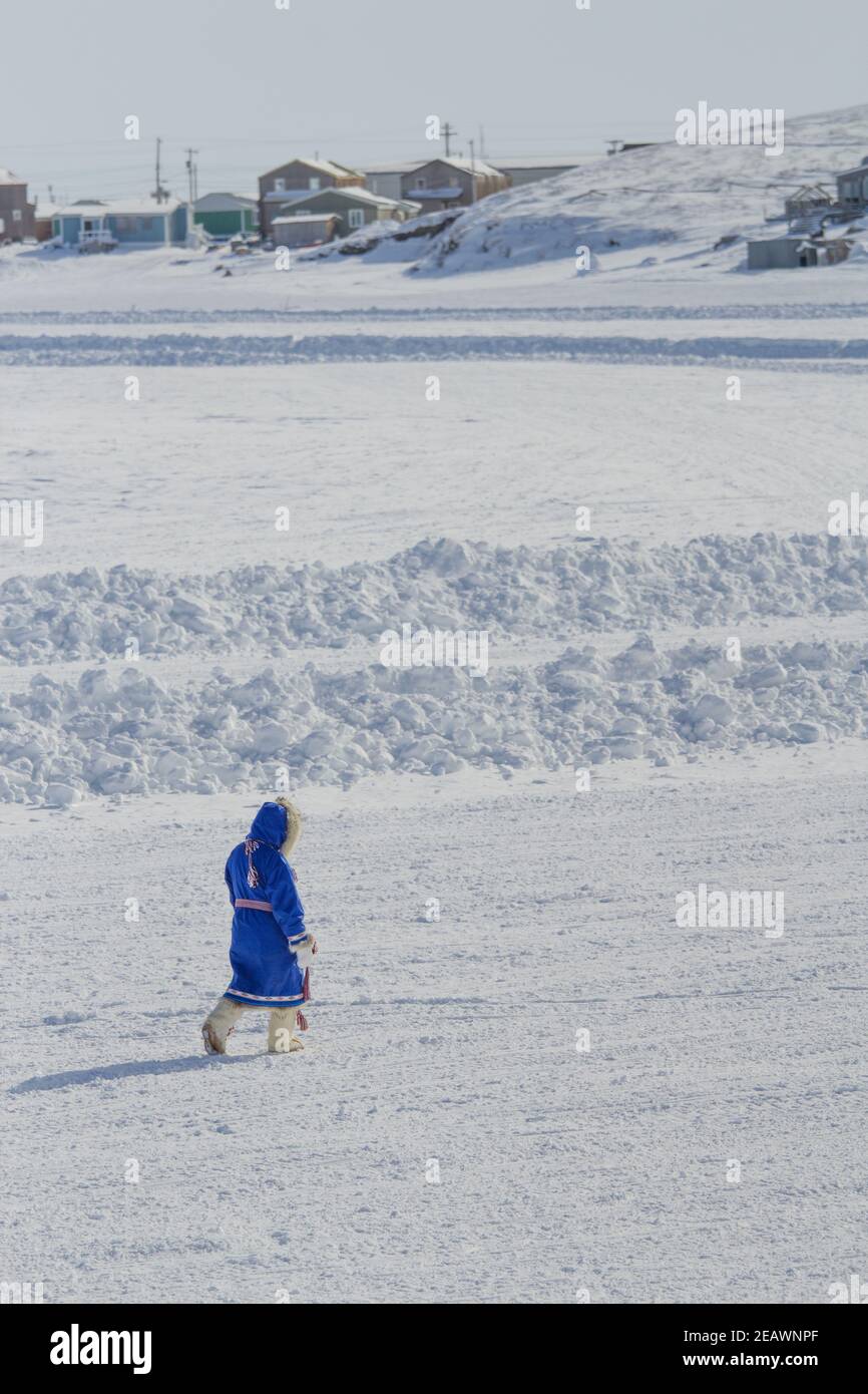 Donna vestita in tradizionale parka indigena e mocassini in inverno, nel borgo artico di Tuktoyaktuk, territori del Nord-Ovest, Artico del Canada. Foto Stock