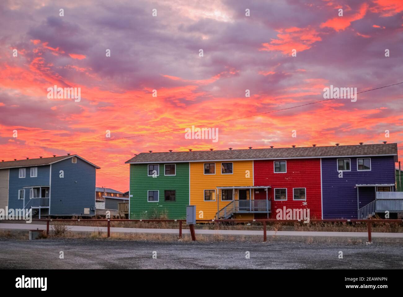 Colorate case a schiera al tramonto nella città di Inuvik, regione del delta del Beaufort, territori del Nord-Ovest, l'Artico occidentale del Canada. Foto Stock