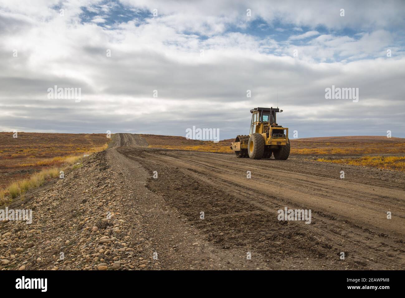 Compattatore vibrante per terreno sull'autostrada Inuvik-Tuktoyaktuk (costruita sopra il permafrost) durante la costruzione autunnale, territori nordoccidentali, Artico del Canada. Foto Stock