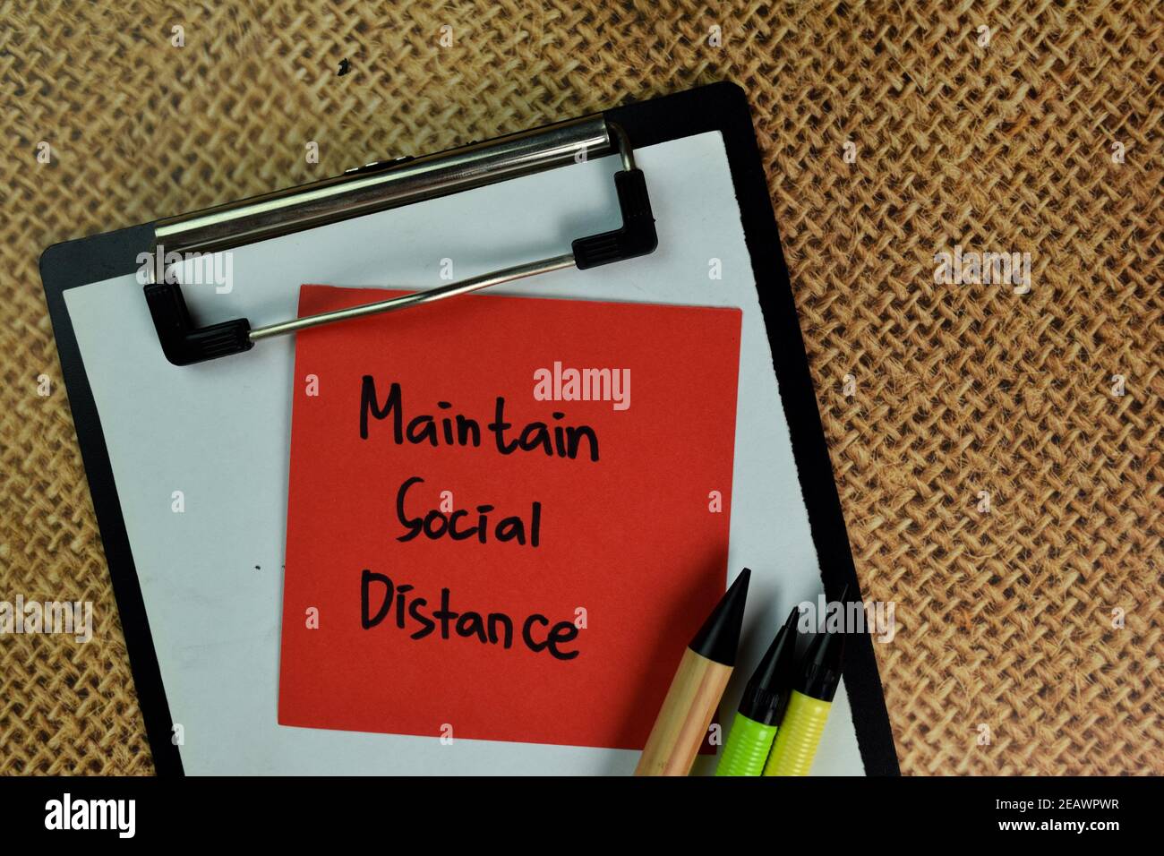 Mantenere la distanza sociale scrivere su note appiccicose isolate su tavola di legno. Foto Stock