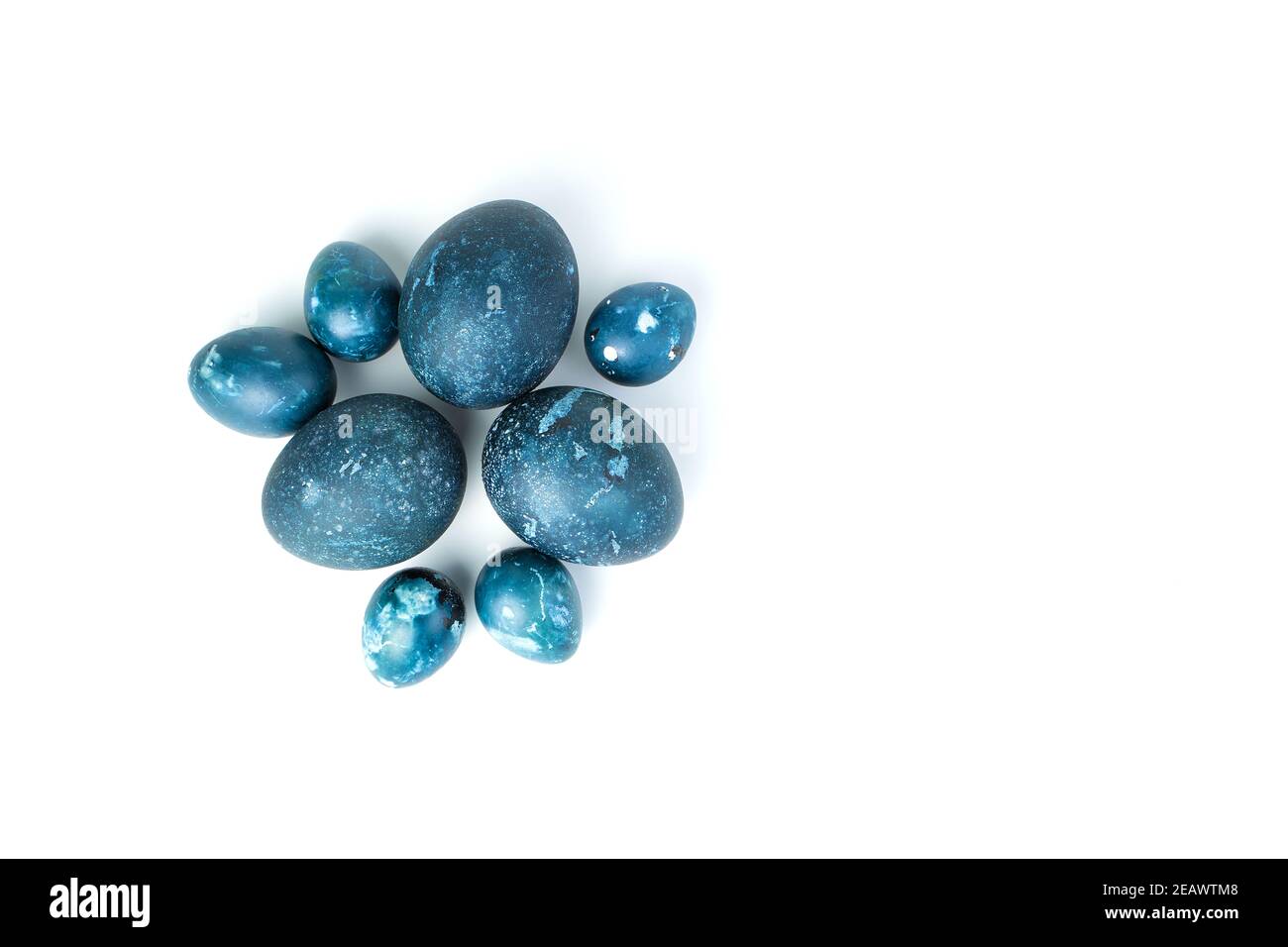 Uova di Pasqua dipinte con colorante blu scuro naturale su sfondo bianco. Foto Stock