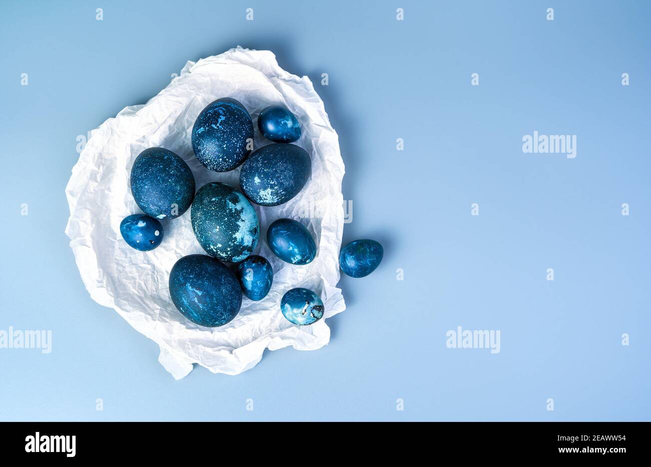 Un set di quaglia e uova di pollo in carta pergamena su sfondo blu. Foto Stock