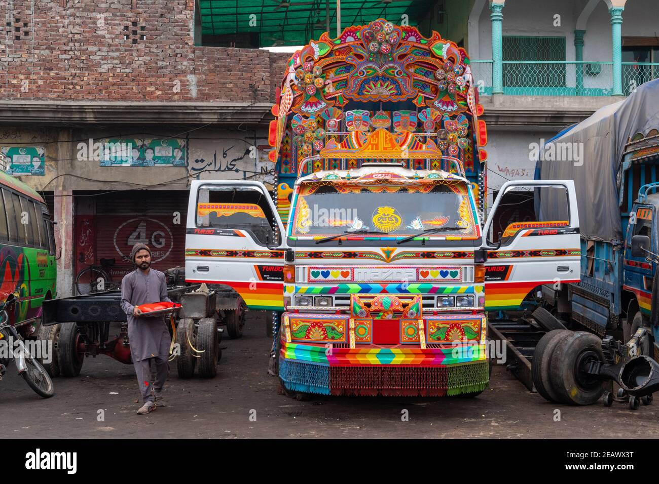 Lavoratori in un'officina di pittura di arte di camion, Lahore, Punjab, Pakistan Foto Stock