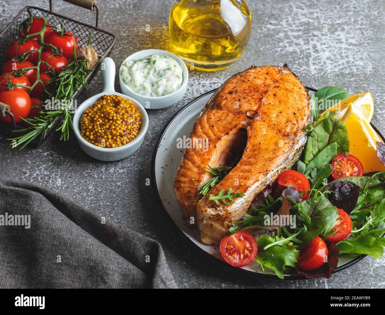 bistecca di salmone arrosto, fritto e al forno con insalata fresca e pomodori vista dall'alto Foto Stock