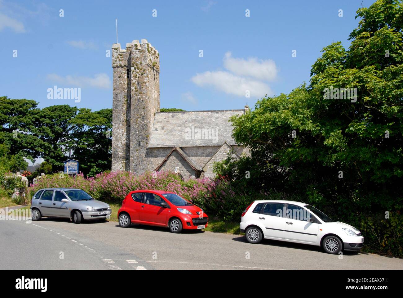 Tre auto parcheggiate di fronte alla chiesa di St Michael e all Angels, Bosherston, Pembrokeshire, Galles Foto Stock