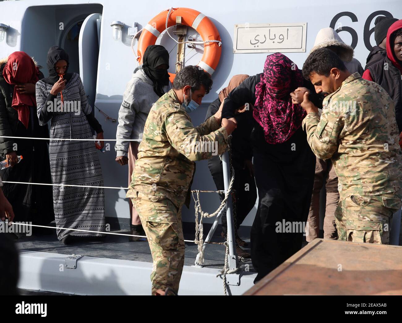 Al Khums, Libia. 10 Feb 2021. I membri della Guardia Costiera libica aiutano gli immigrati a sbarcare da una nave nel porto di al Khums, Libia, il 10 febbraio 2021. L'Organizzazione internazionale per la migrazione (OIM), affiliata alle Nazioni Unite, ha affermato che mercoledì oltre 200 immigrati clandestini sono stati salvati al largo delle coste libiche. Credit: Hamza Turkia/Xinhua/Alamy Live News Foto Stock