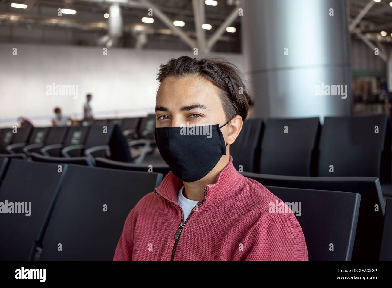 Uomo che indossa la maschera all'aeroporto. I temi viaggiano in nuova normalità, coronavirus e protezione personale. Foto Stock