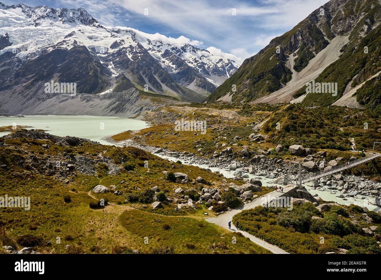 Swingbridge sul percorso della Hooker Valley, con il lago Mueller e il monte Sefton, l'Aoraki Mt Cook National Park Foto Stock