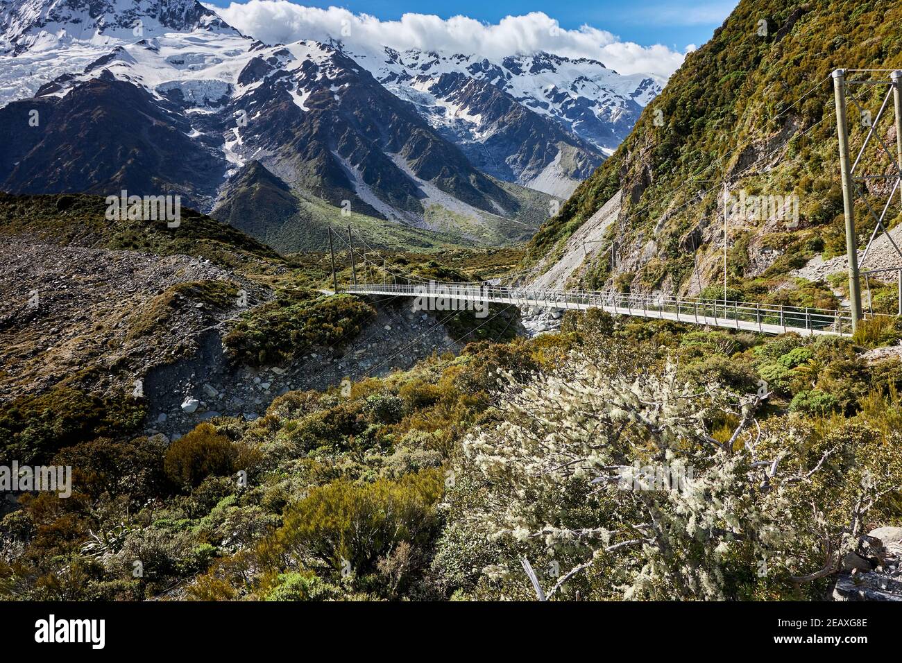 Swingbridge sul percorso della Hooker Valley, con il lago Mueller e il monte Sefton, l'Aoraki Mt Cook National Park Foto Stock