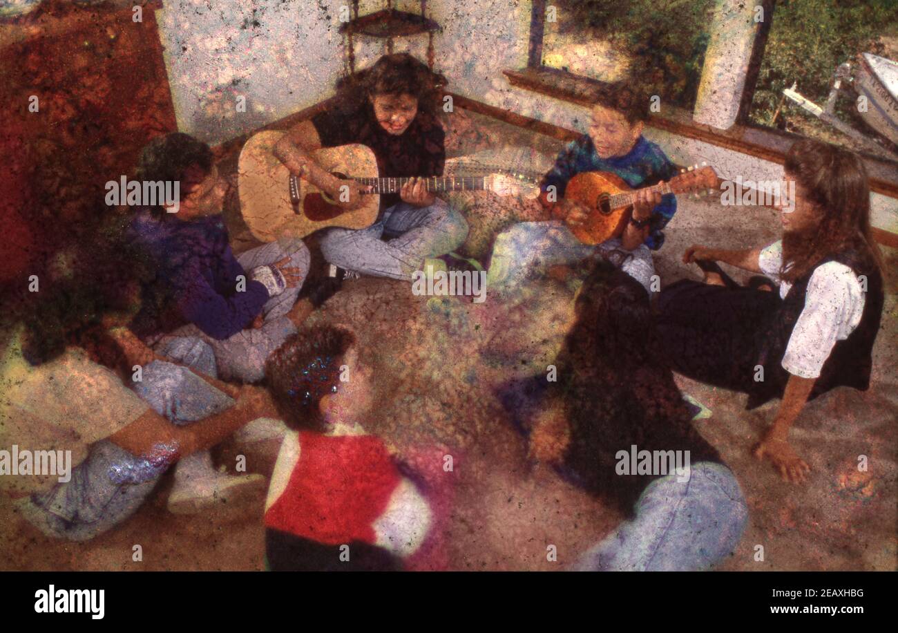 Ragazzi giovani di alta età che suonano chitarra e mandolino per gli amici in soggiorno. VERSIONE DEL MODELLO RE-289 ©1989 Bob Daemmrich BAD8166C Foto Stock